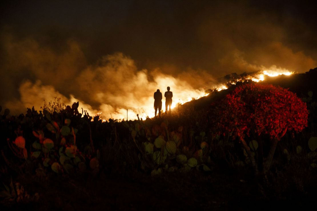 People watch from a hillside during the Silverado Fire in Lake Forest, California, on Monday, Oct. 26, 2020. 