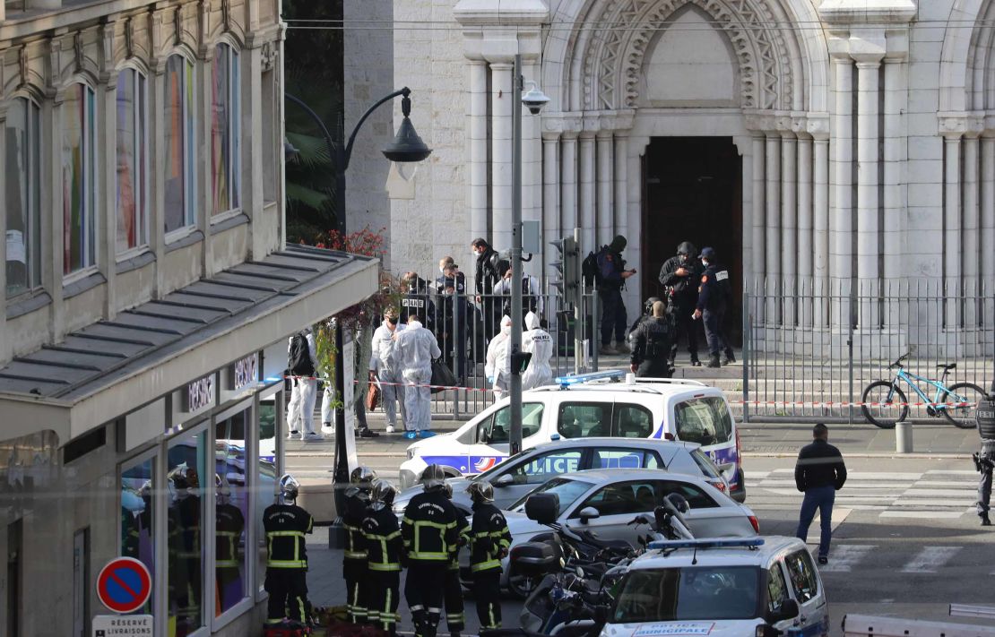 French elite police enter the Basilica of Notre-Dame de Nice as forensics officers wait outside after a knife attack on October 29.
