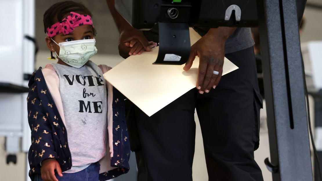 Two-year-old Aissatou Barry accompanies her father at an early voting center at Union Market Tuesday in Washington, DC.