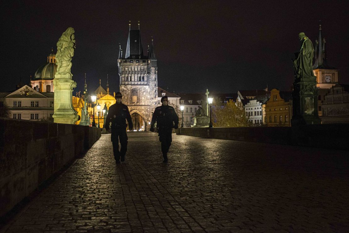 Police officers walk across the empty Charles Bridge in Prague during the night-time curfew imposed by the Czech government on October 28.