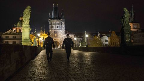 Police officers walk across the empty Charles Bridge in Prague during the night-time curfew imposed by the Czech government on October 28.