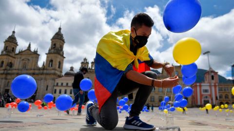A man places balloons with the colors of the Colombian national flag at Bolivar Square in Bogota on Oct. 2, 2020, to mark the fourth anniversary of the referendum to ratify the peace deal between the government and FARC that was narrowly rejected by voters.