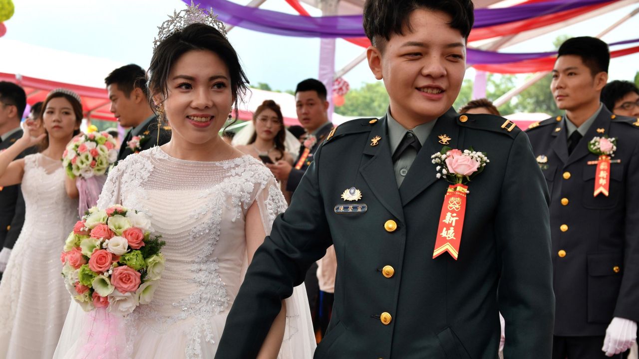 Newly-wedded same-sex couple Chen Ying-hsuan (R) and Li Li-chen take part in a mass wedding at Taiwan's Army Command Headquarters in Taoyuan.