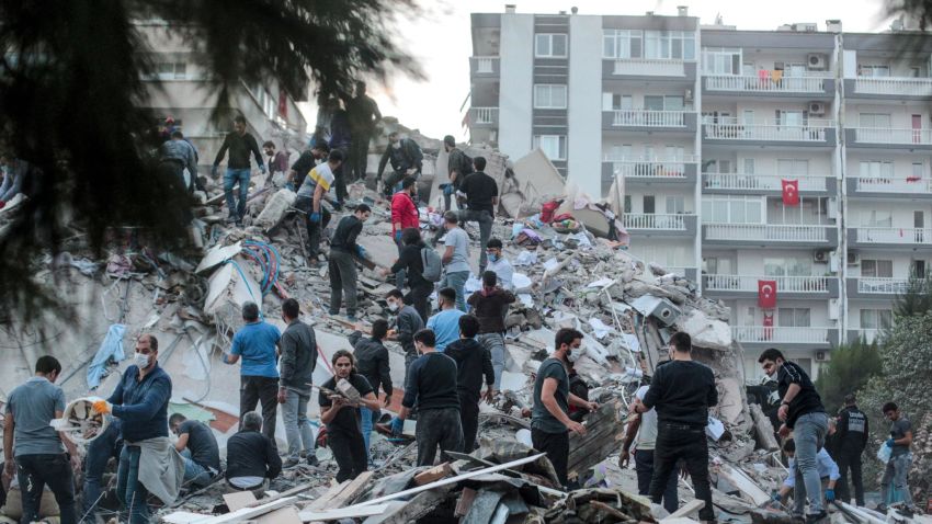 Volunteers clear rubbles as they search for survivors in a collapsed building after a strong earthquake struck the country's western coast and parts of Greece, killing four people and injuring 120, in Izmir, on October 30, 2020. - A powerful earthquake hit Greece and Turkey, causing buildings to collapse and a sea surge that flooded streets in the Turkish resort city of Izmir. Greek public television said the quake also caused a mini-tsunami on the eastern Aegean Sea island of Samos, damaging buildings. The US Geological Survey said the 7.0 magnitude quake was registered 14 kilometres (8.6 miles) off the Greek town of Karlovasi on Samos. (Photo by Mert CAKIR / AFP) (Photo by MERT CAKIR/AFP via Getty Images)