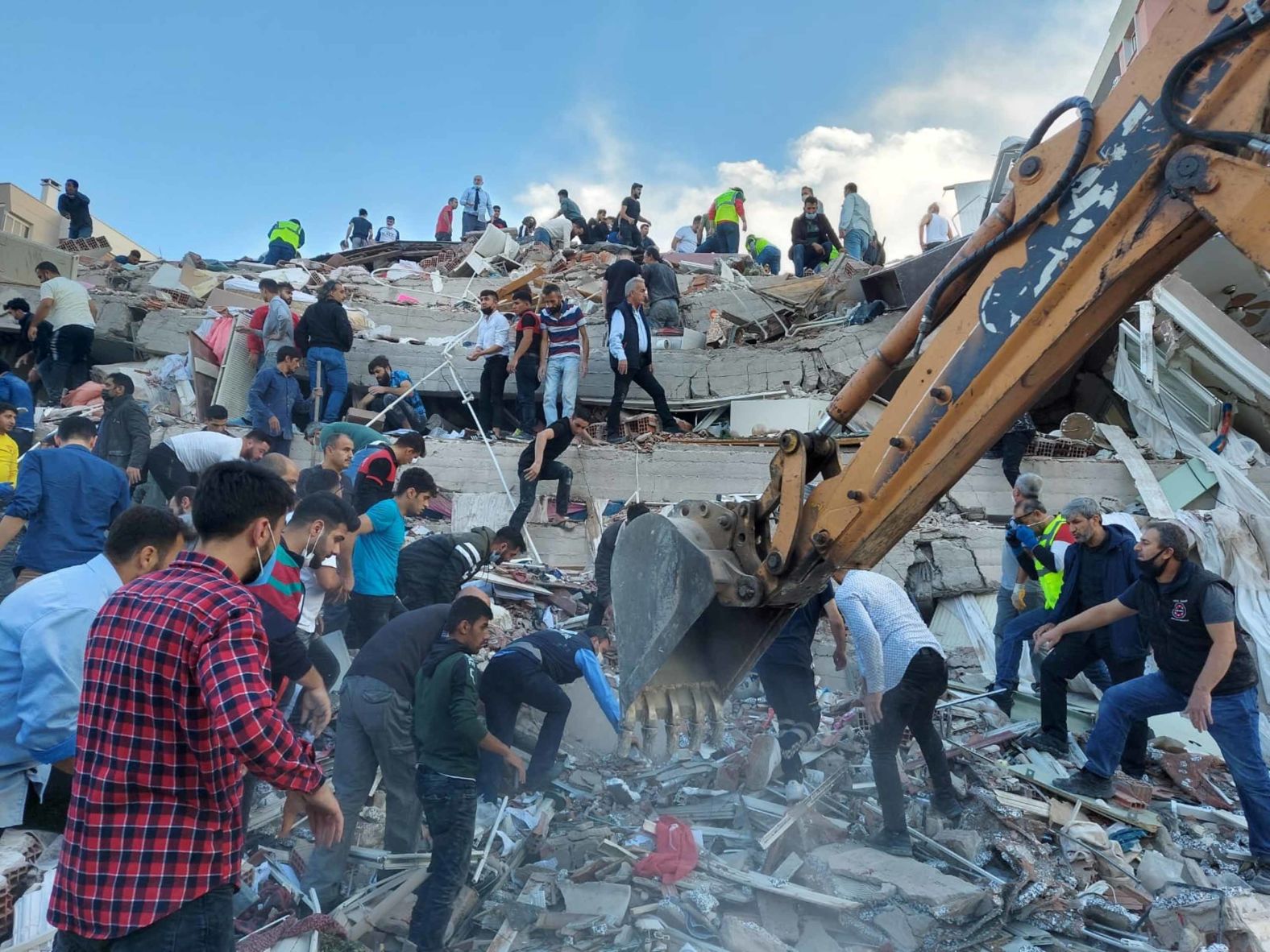 People search for survivors in a building that collapsed in Izmir.