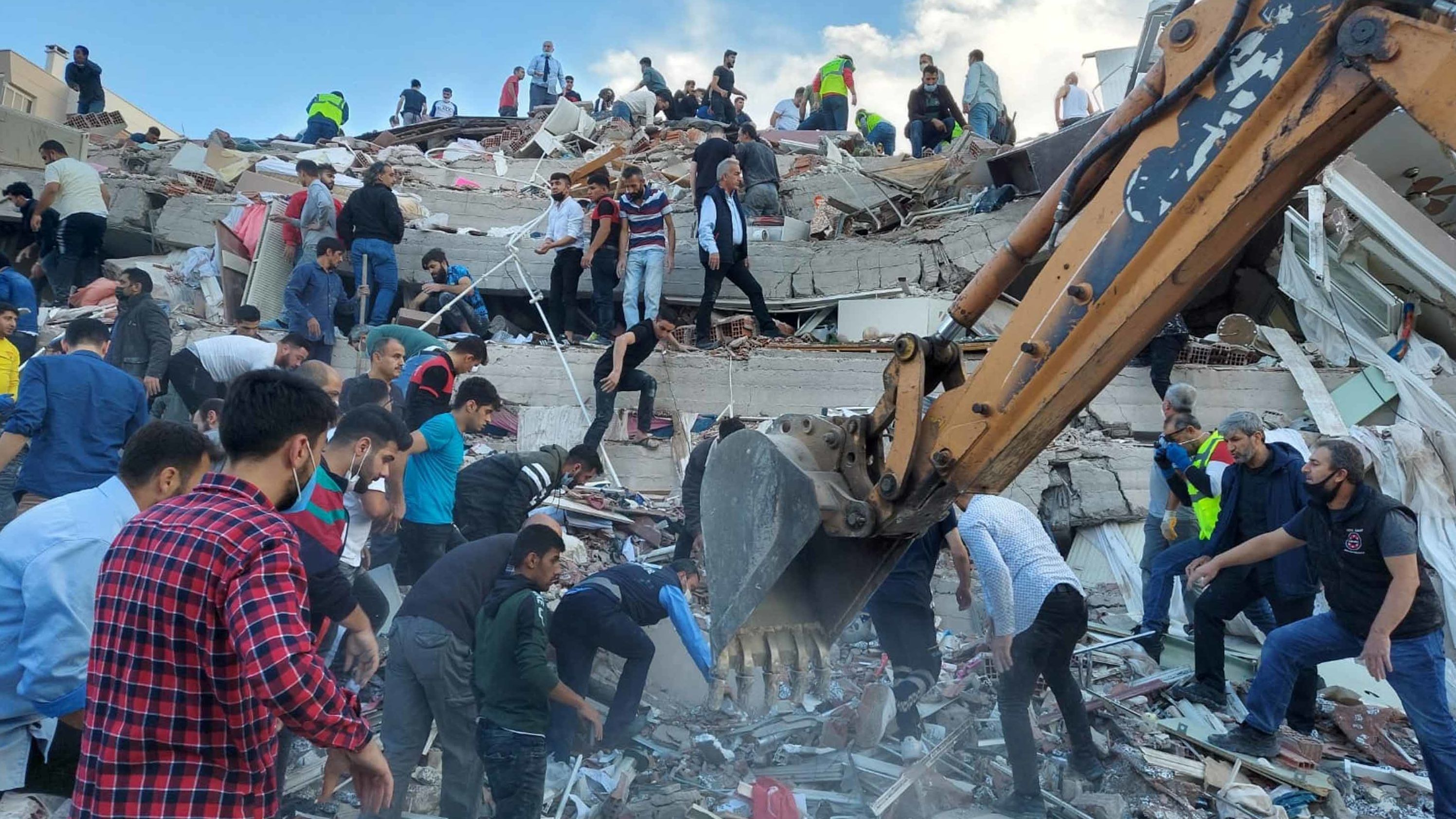People search for survivors in a building that collapsed in Izmir.