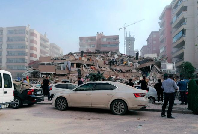 Volunteers work at the scene of a collapsed building in Izmir.