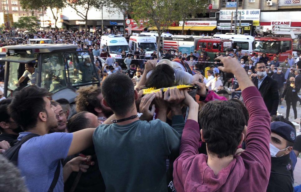 Rescuers carry a wounded person who was pulled from debris in Izmir.