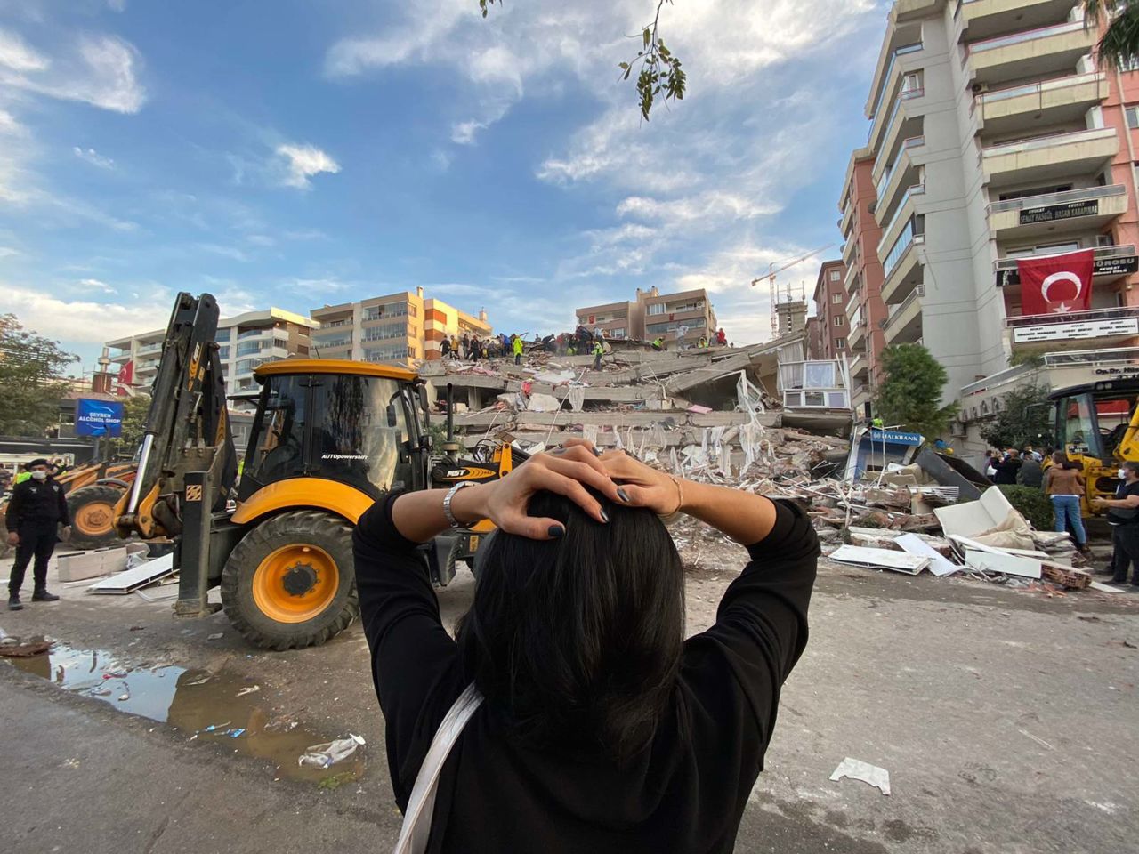 A woman reacts as search-and-rescue teams work at a building site in Izmir.