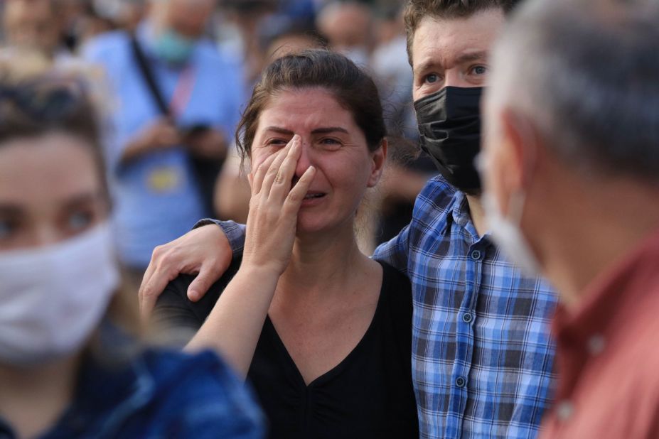 A woman reacts as search-and-rescue teams work through the debris of a collapsed building in Izmir.