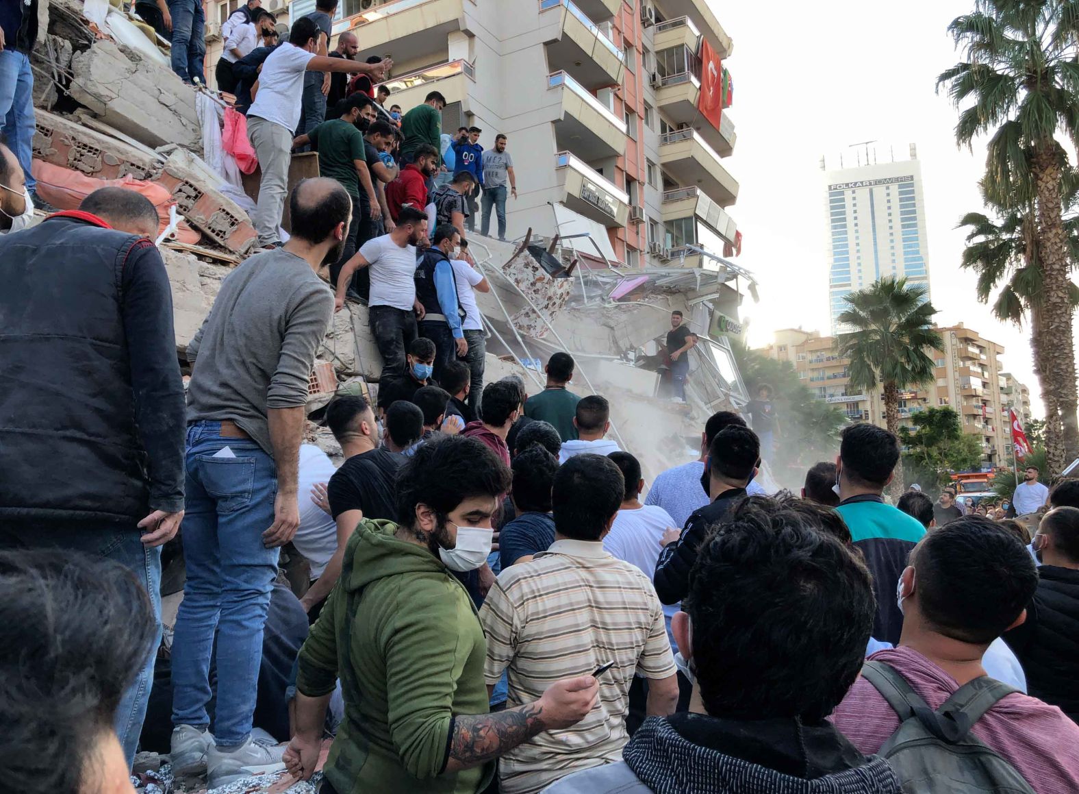 People try to save residents trapped in the debris of a collapsed building in Izmir on Friday, October 30.