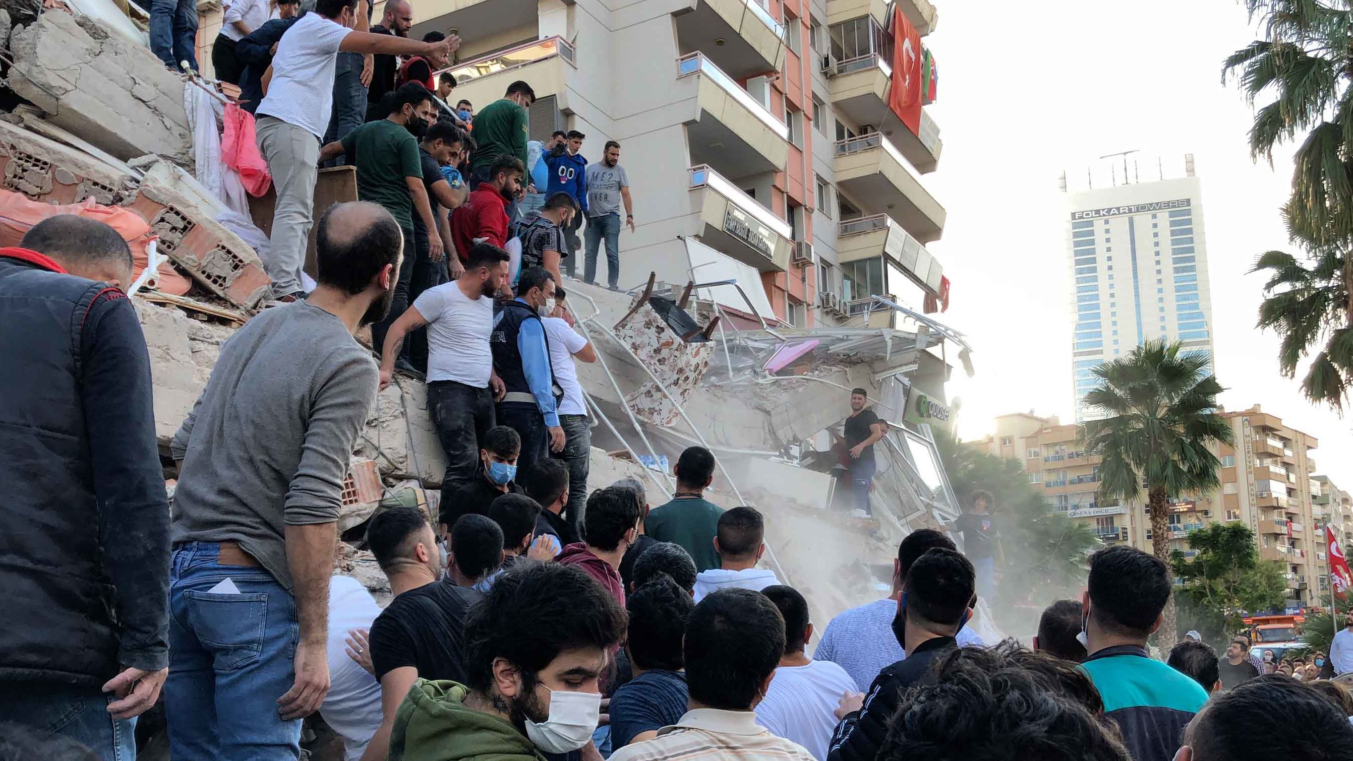 People try to save residents trapped in the debris of a collapsed building in Izmir on Friday, October 30.