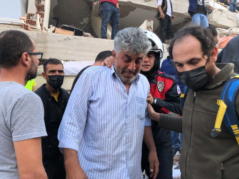 A man weeps as people try to save residents trapped under rubble in Izmir.