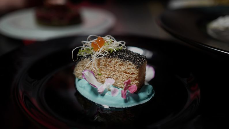In this dish, the feather-based protein is transformed into a "fish fillet," flavored with salt water and crusted with chia seeds. It's served with a creamy seafood sauce, garnished with dill and topped with salmon roe.