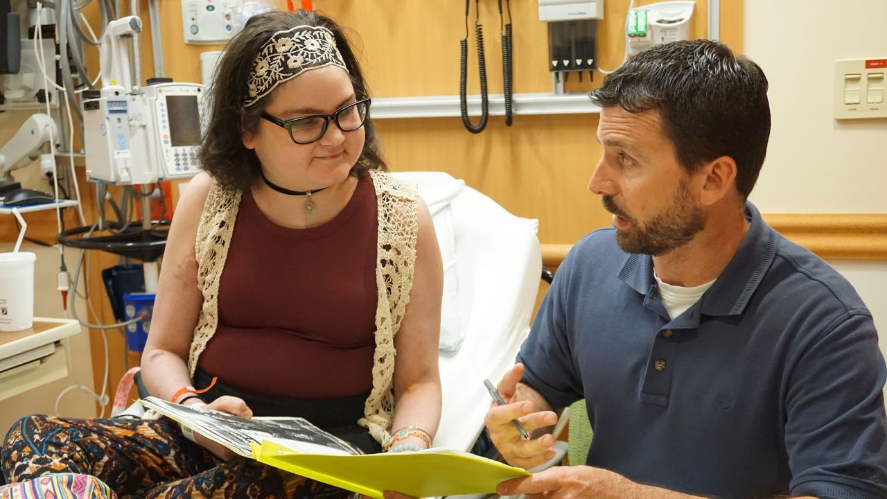 Cancer patient Amber Pflughoeft works with her teacher Mike Trocchio, at Children's Wisconsin hospital in Milwaukee in 2018. She died in September after sending in an early ballot.