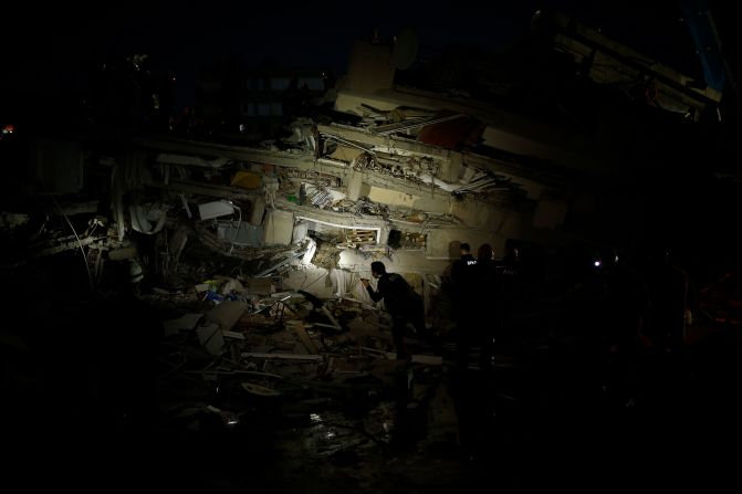 Rescue workers search for survivors in the debris of a collapsed building in Izmir.