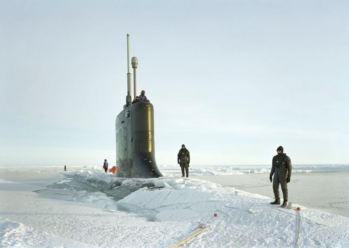 Ship divers are pictured atop the USS New Hampshire as it crests through ice in arctic waters in 2011, from Lê's "Events Ashore" series.