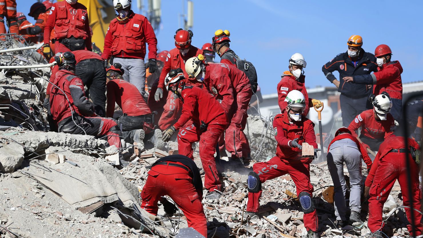 Members of rescue services search the debris of a collapsed building for survivors in Izmir, Turkey, on Sunday.