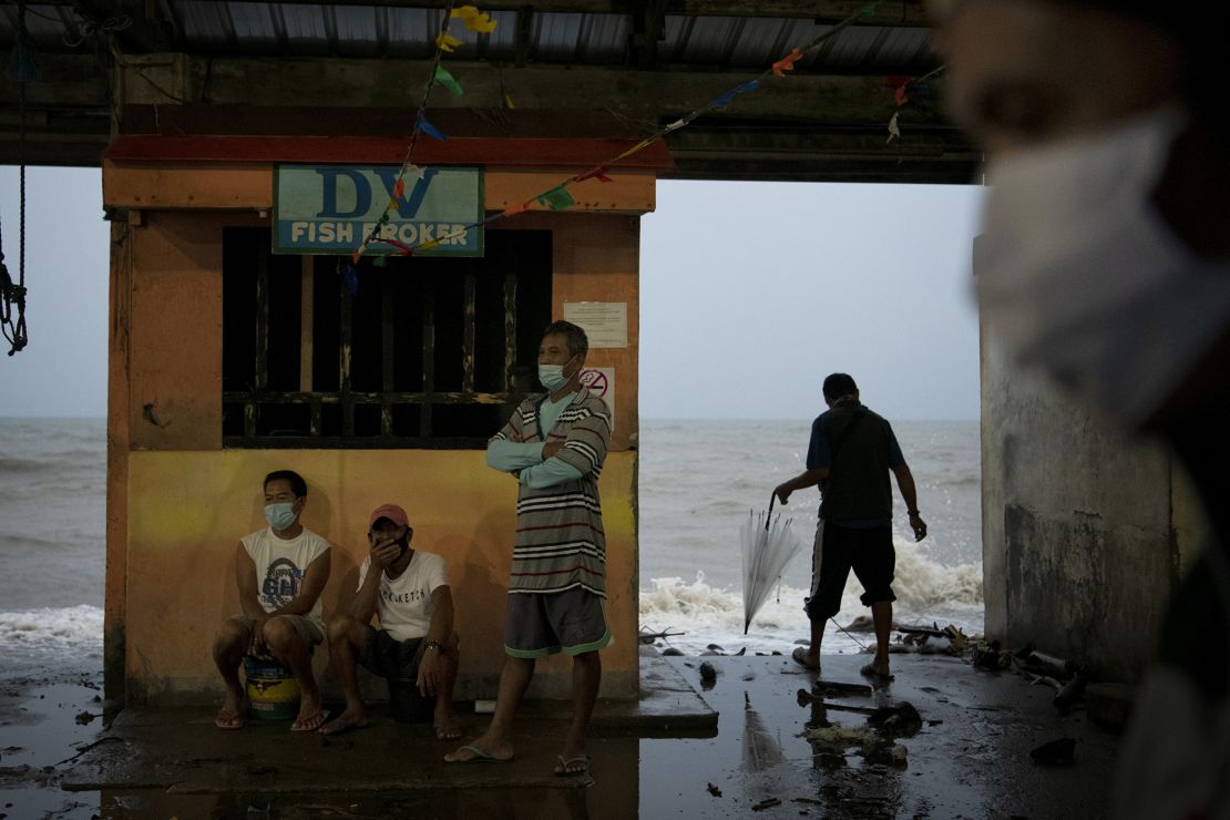 People monitor the sea level and waves as typhoon Goni makes landfall on Sunday in Atimonan, Philippines.