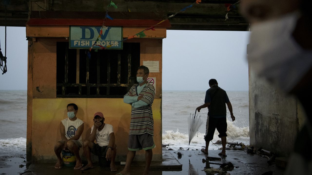 People monitor the sea level and waves as typhoon Goni makes landfall on Sunday in Atimonan, Philippines.