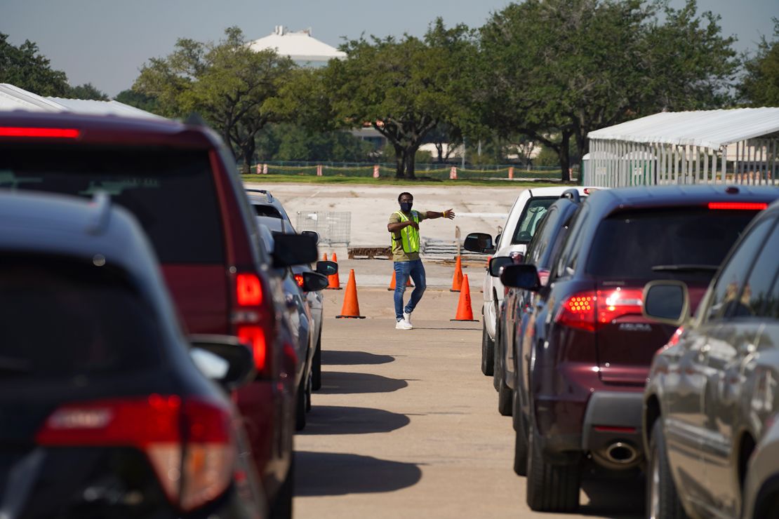 An election worker guides voters in cars at a drive-through mail ballot drop-off site at NRG Stadium in Houston, Texas, last year.