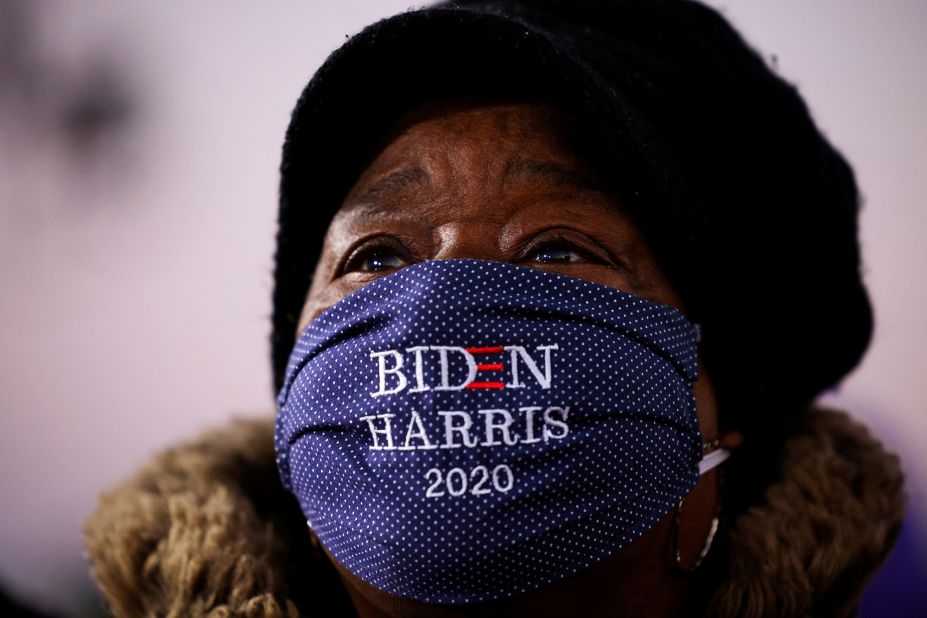 A woman watches Biden speak at a drive-in event in Detroit on October 31.