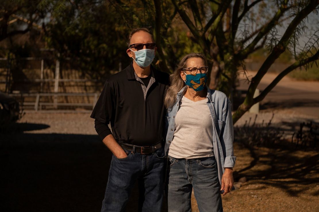 Ann Whitmire, right, and her husband William are pictured outside their Phoenix home. Ann, who contracted the coronavirus in June, considered voting for Donald Trump this year until she heard the President make a series of false claims about pandemic.
