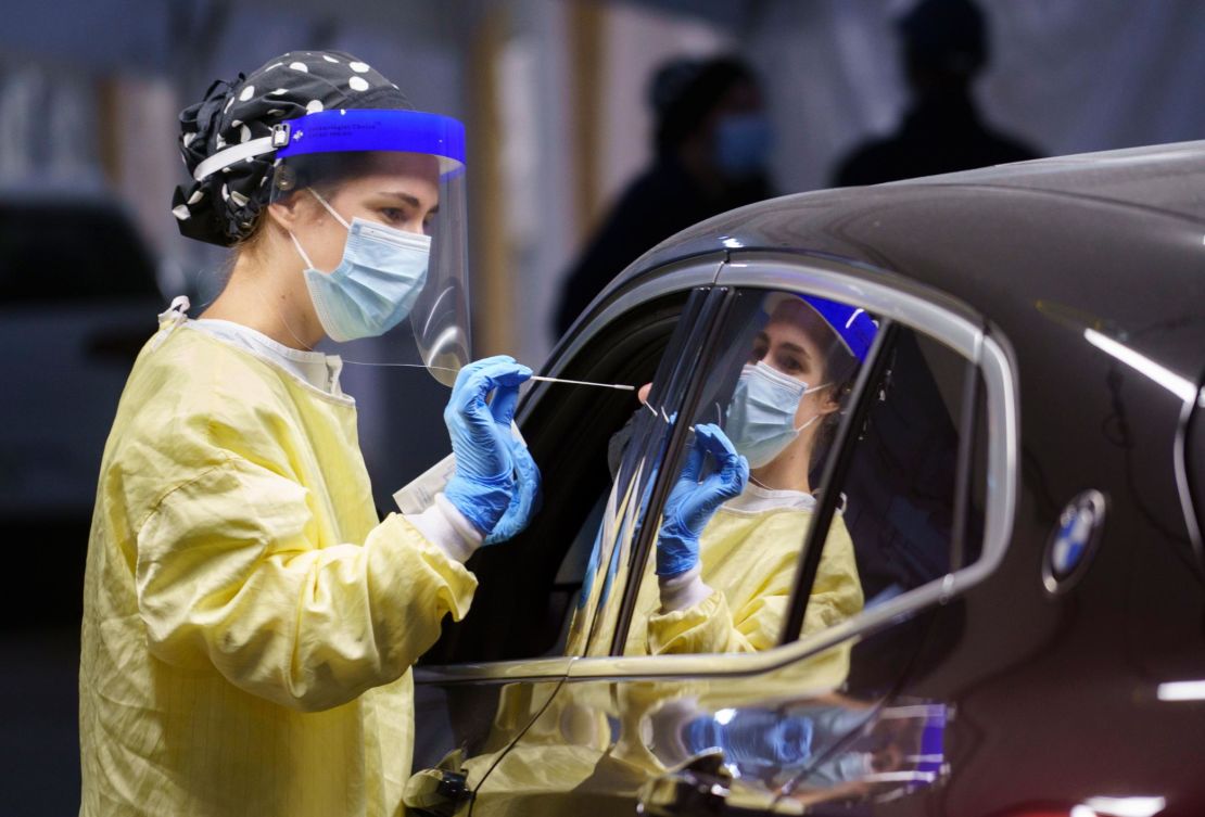 A nurse collects a sample on a patient at a drive-thru Covid-19 clinic in Montreal, Wednesday, Oct. 21, 2020.