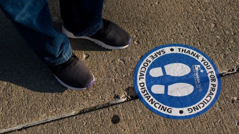 An early voter stands near a social distancing marker October 6 in Columbus, Ohio. Voters recovering from Covid-19 can vote, the US CDC says.
