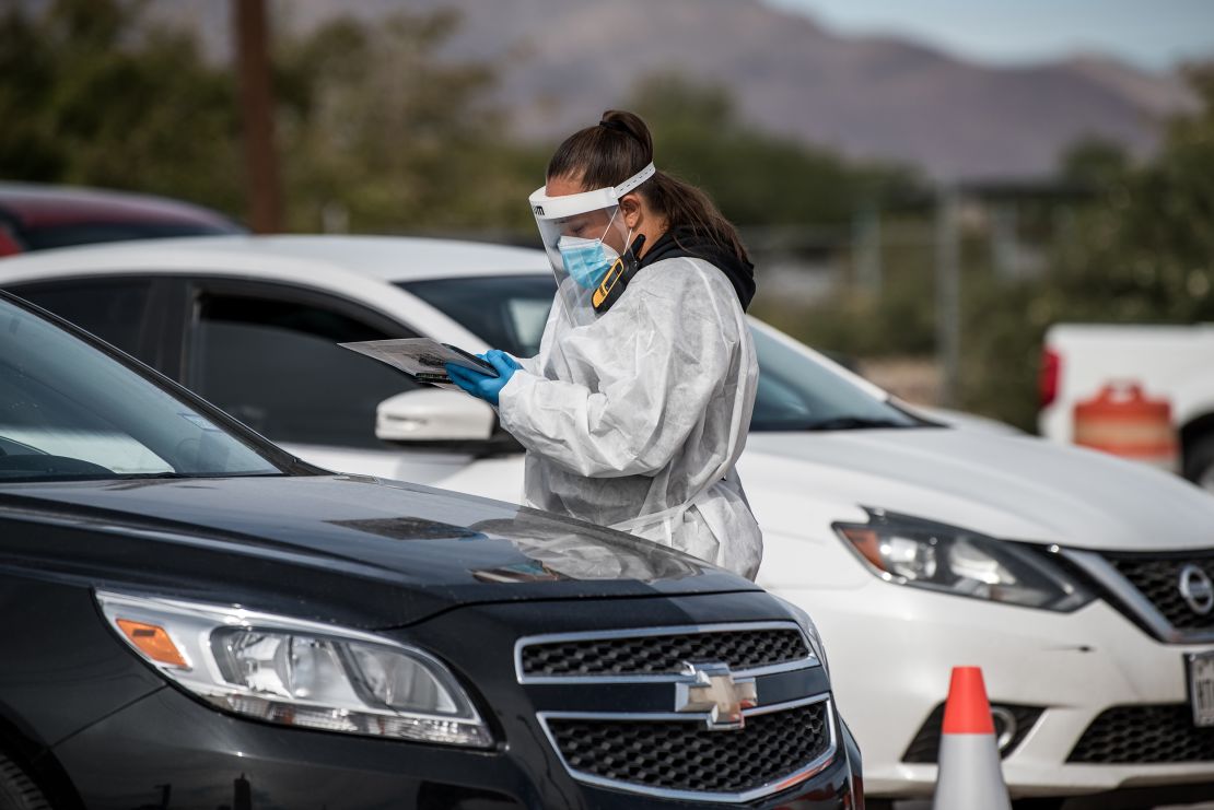 An attendant talks to a person waiting in their car at a coronavirus testing site October 31 in El Paso, Texas.