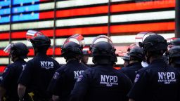 TOPSHOT - NYPD police officers watch demonstrators in Times Square on June 1, 2020, during a "Black Lives Matter" protest. - New York's mayor Bill de Blasio today declared a city curfew from 11:00 pm to 5:00 am, as sometimes violent anti-racism protests roil communities nationwide.Saying that "we support peaceful protest," De Blasio tweeted he had made the decision in consultation with the state's governor Andrew Cuomo, following the lead of many large US cities that instituted curfews in a bid to clamp down on violence and looting. (Photo by TIMOTHY A. CLARY / AFP) (Photo by TIMOTHY A. CLARY/AFP via Getty Images)