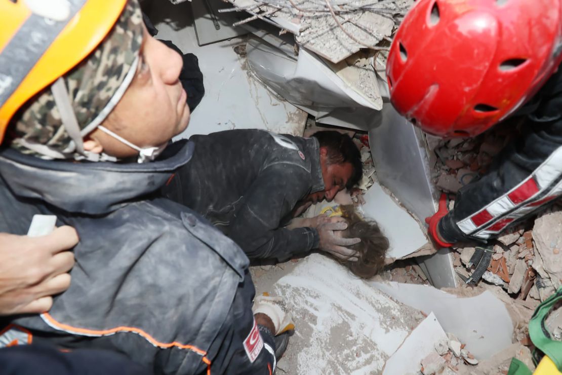  A rescue worker cradles the face of the 2-year-old in the middle of the effort to pull her from the rubble.