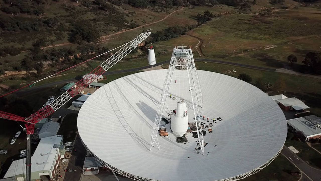 A 400-ton crane lifts the new X-band cone into the 70-meter (230-feet) Deep Space Station 43 dish located in Canberra, Australia. The antenna is the only one that can issue commands to NASA's Voyager 2 probe in interstellar space.