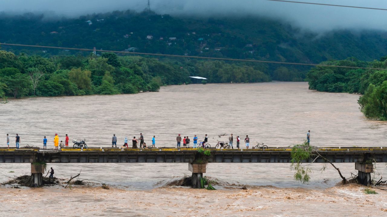 People watch the Humuya river flooding due to heavy rains caused by Hurricane Eta in Santa Rita, Department of Yoro.