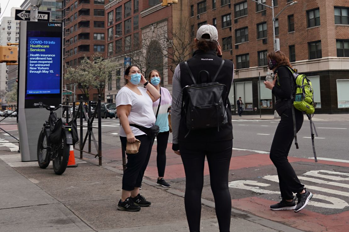 Women wearing protective masks speak on the street in New York City on April 5. 