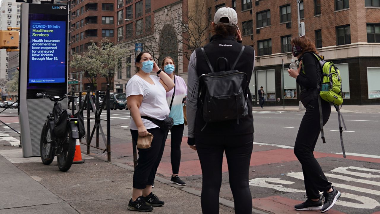 Women wearing protective masks speak on the street in New York City on April 5. 