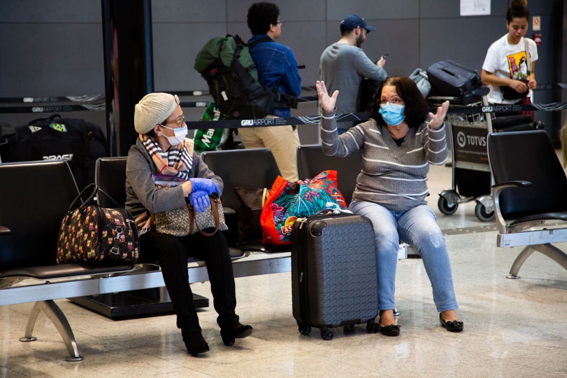 Passengers wear protective face masks while talking in Brazil's São Paulo/Guarulhos International Airport on March 15.