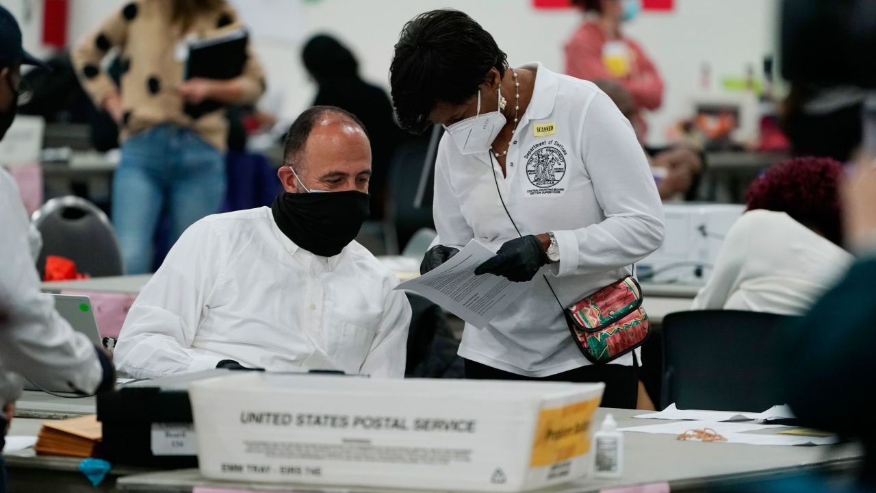 A worker checks with an election supervisor at the central counting board, Wednesday, Nov. 4, 2020, in Detroit. (AP Photo/Carlos Osorio)