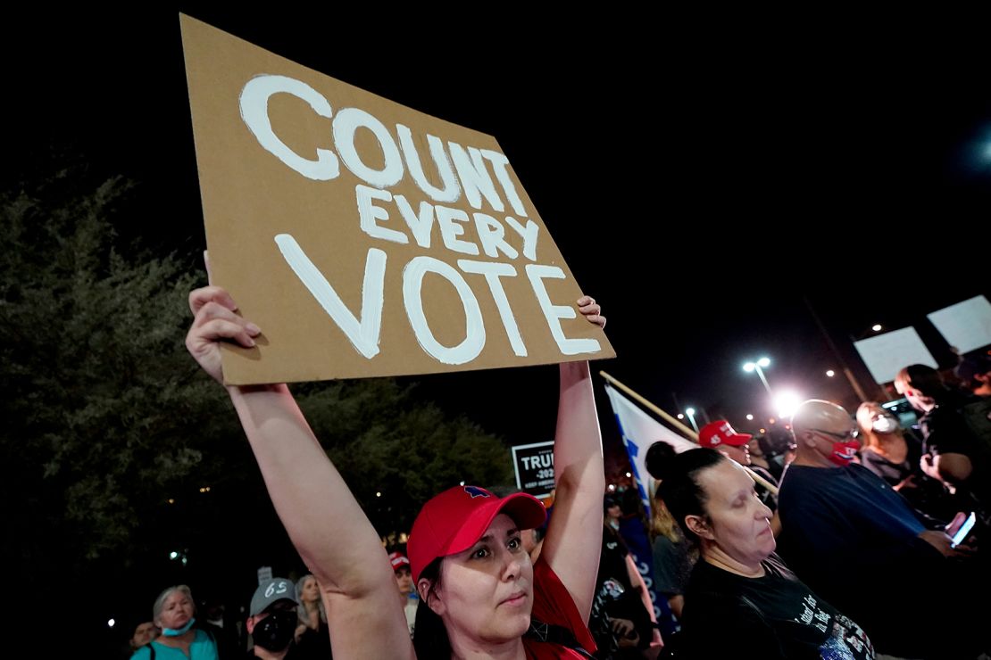 A supporter of President Donald Trump holds a "Count every vote" sign at a rally Wednesday night outside the Maricopa County vote counting center in Phoenix.