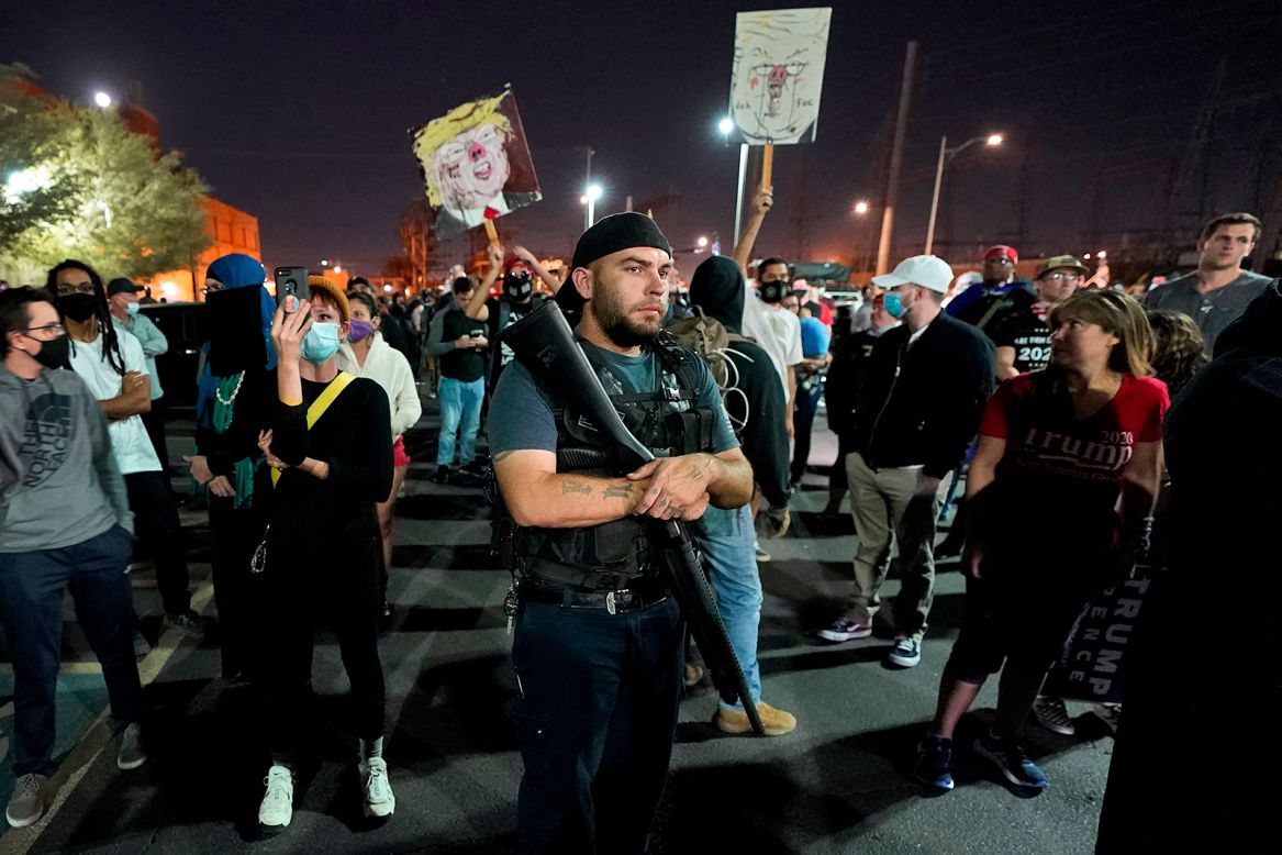 Supporters of US President Donald Trump rally outside the Maricopa County Recorder's Office in Phoenix on Wednesday, November 4. A couple of counterprotesters are standing in the back.