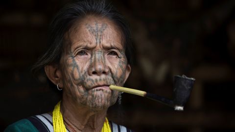 This photo taken on March 3, 2020 shows a tattooed Chin ethnic woman smoking at her house in a village of Chin State, western Myanmar.