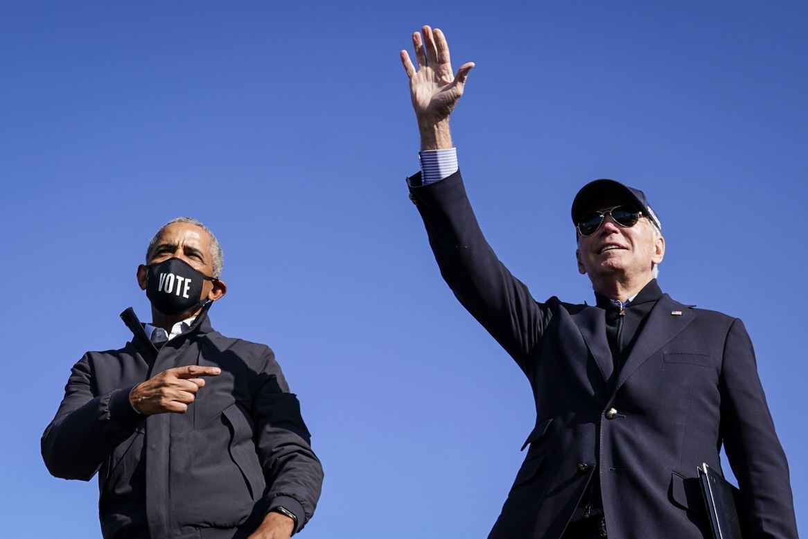 Former US President Barack Obama, left, joins Democratic presidential nominee Joe Biden for a drive-in campaign rally in Flint, Michigan, on Saturday, October 31.