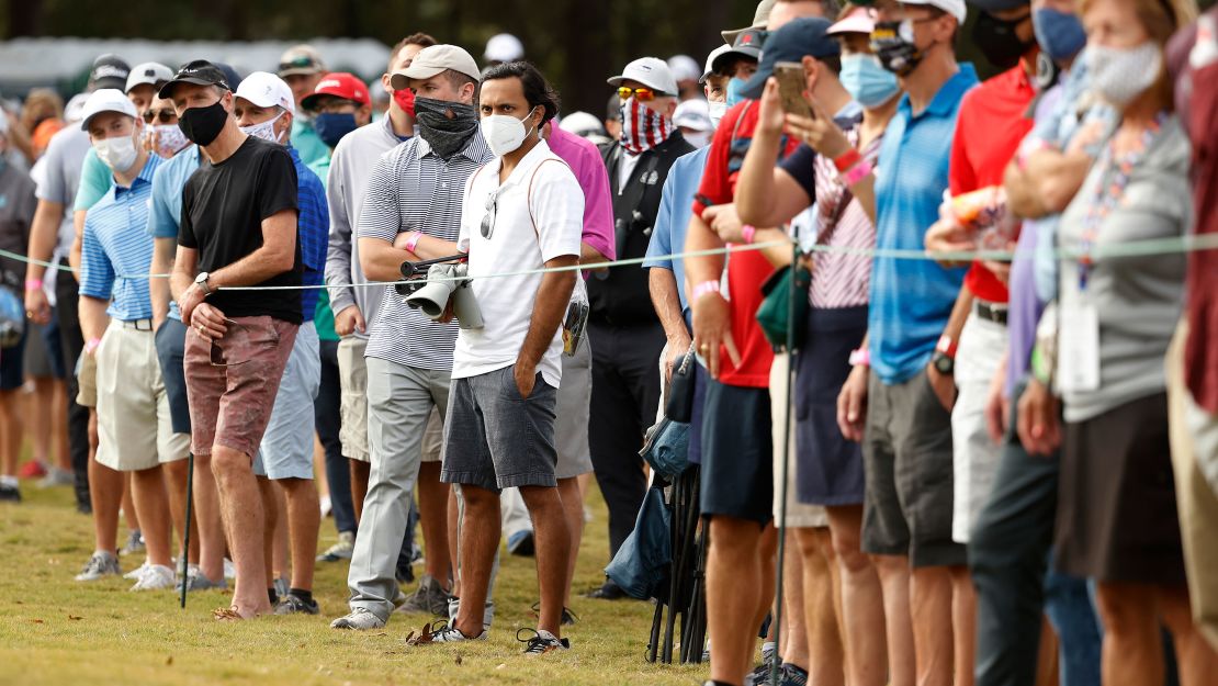 Fans, wearing masks, watch action on the ninth green during the first round of the Houston Open.