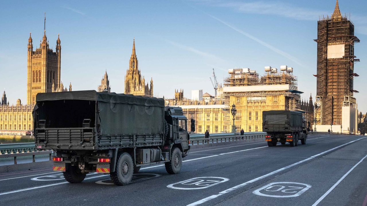 Military vehicles cross Westminster Bridge on March 24, 2020, after army personnel delivered a consignment of medical masks to St Thomas' Hospital, London.