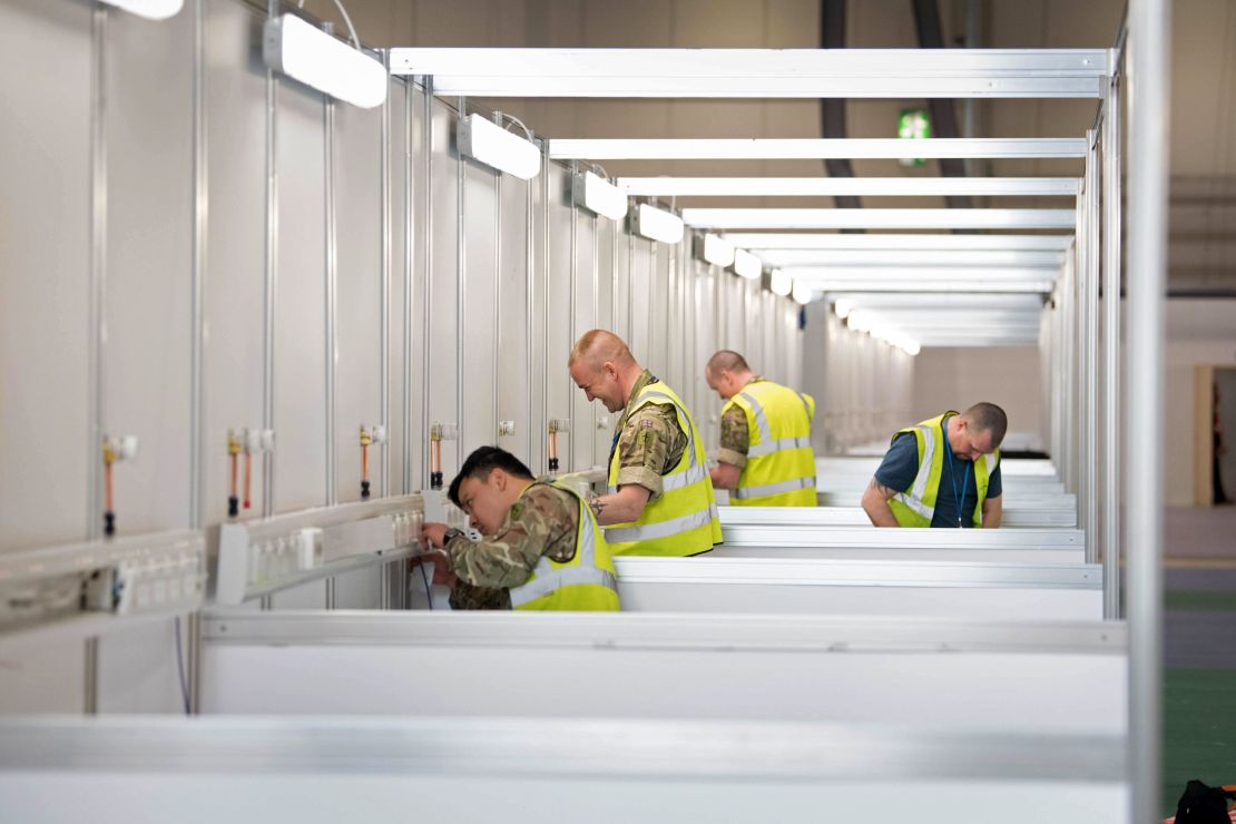 Members of the military and private contractors help to transform the ExCel centre in London into an NHS Nightingale Hospital for coronavirus patients, on March 30, 2020.