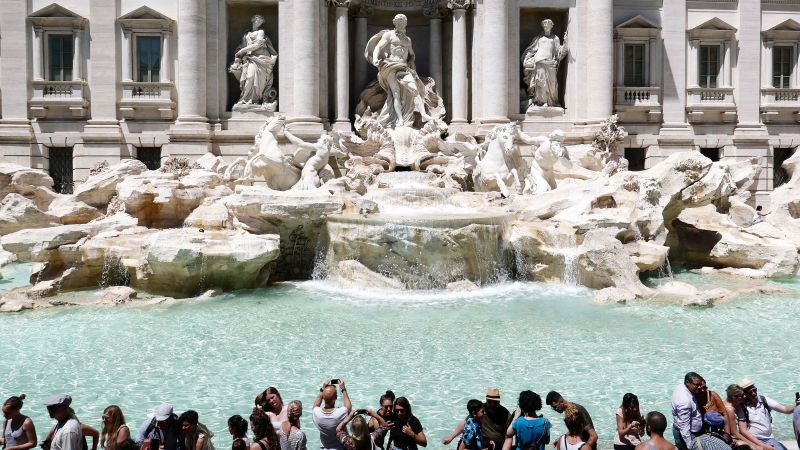 Video ukazuje turistu, jak leze na Fontánu di Trevi v Římě, aby naplnil láhev vody