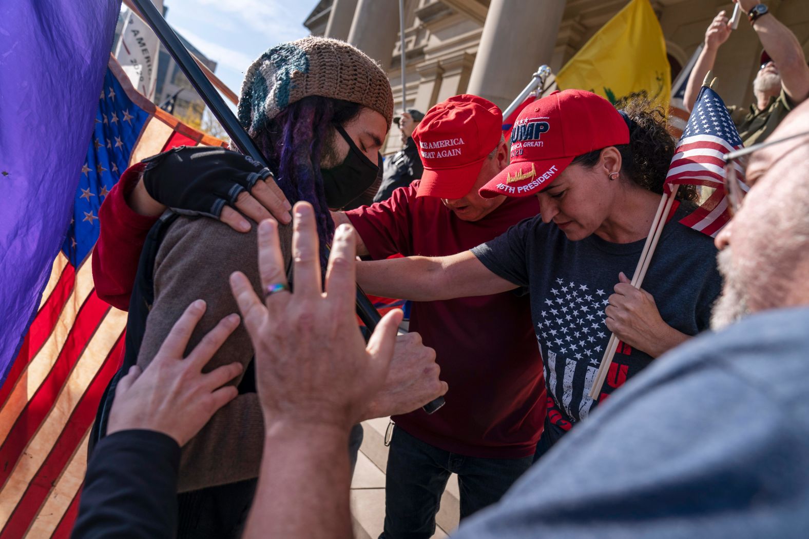 Trump supporters pray with a counterprotester in Lansing, Michigan, after Biden was projected as the winner.