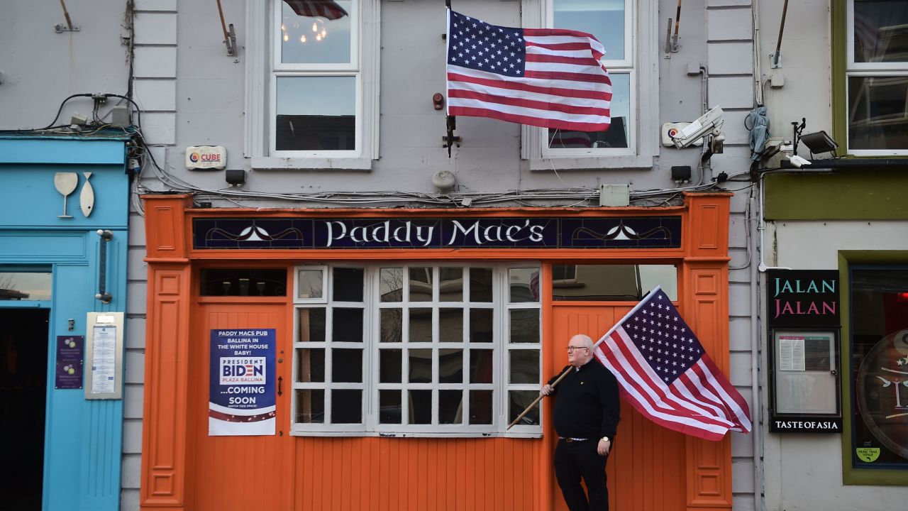 Paddy Macs bar owner Michael Carr stands outside his pub with an American flag on November 7, 2020. 