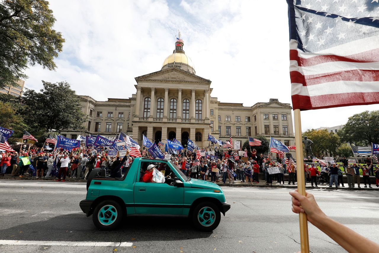 A Biden supporter drives past Trump supporters who had gathered in front of the Georgia State Capitol in Atlanta.