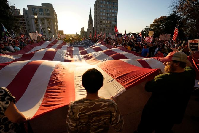 Supporters of President Donald Trump unfurl a giant American flag outside the State Capitol in Harrisburg, Pennsylvania, after Biden's win was projected on November 7.